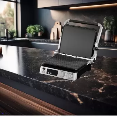 Grill elétrico aberto com placas de grelha pretas sobre bancada de mármore escuro numa cozinha moderna.