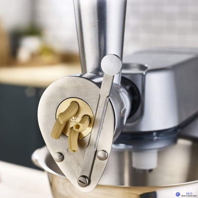 Máquina de massa elétrica metálica a preparar massa tubular numa cozinha