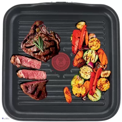 Grelhador quadrado com bife grelhado e legumes coloridos.