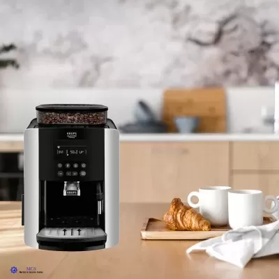 Máquina de café KRUPS preta numa cozinha moderna com croissant e copos brancos