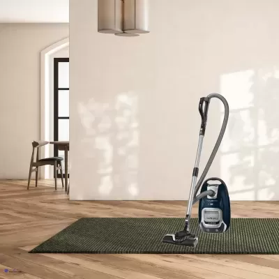 aspirador de pó azul sobre tapete verde em chão de madeira