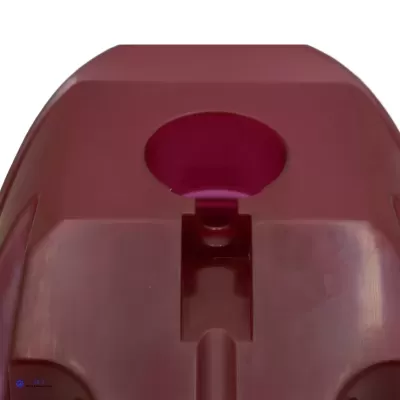 Objeto plástico vermelho com abertura circular e relevo