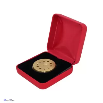 Estojo vermelho aberto com objeto circular dourado dentro.