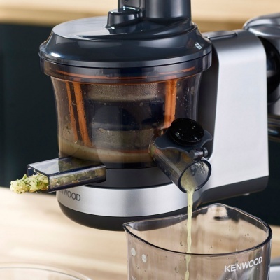 Extractor de sumos Kenwood a extrair sumo para um copo transparente