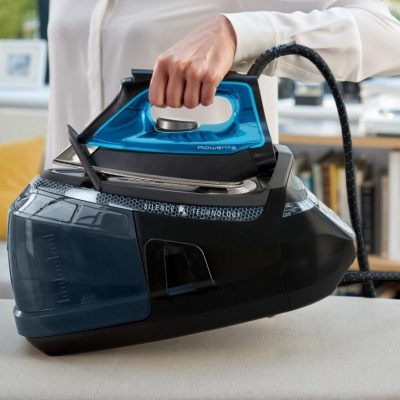 Ferro a vapor azul e preto da marca Rowenta sobre base preta em ambiente interior