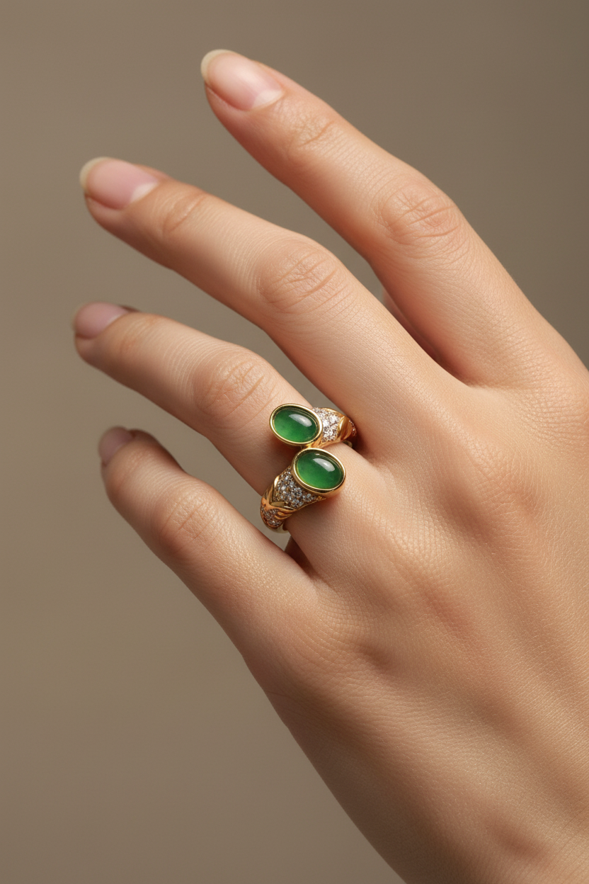 Anel dourado com pedras verdes e cristais numa mão