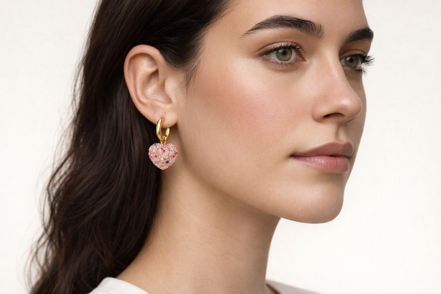 Brinco pendente em forma de coração com pedrinhas rosas e dourado