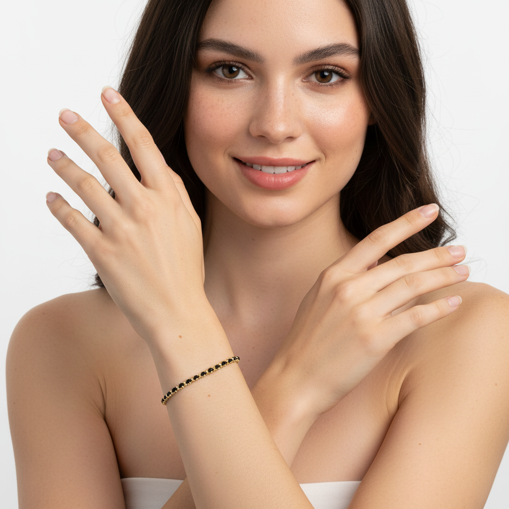 Pulseira dourada com pedras negras no pulso de uma mulher com fundo branco