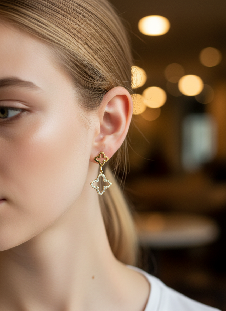 Brinco pendente dourado em forma de trevo com pedras brilhantes