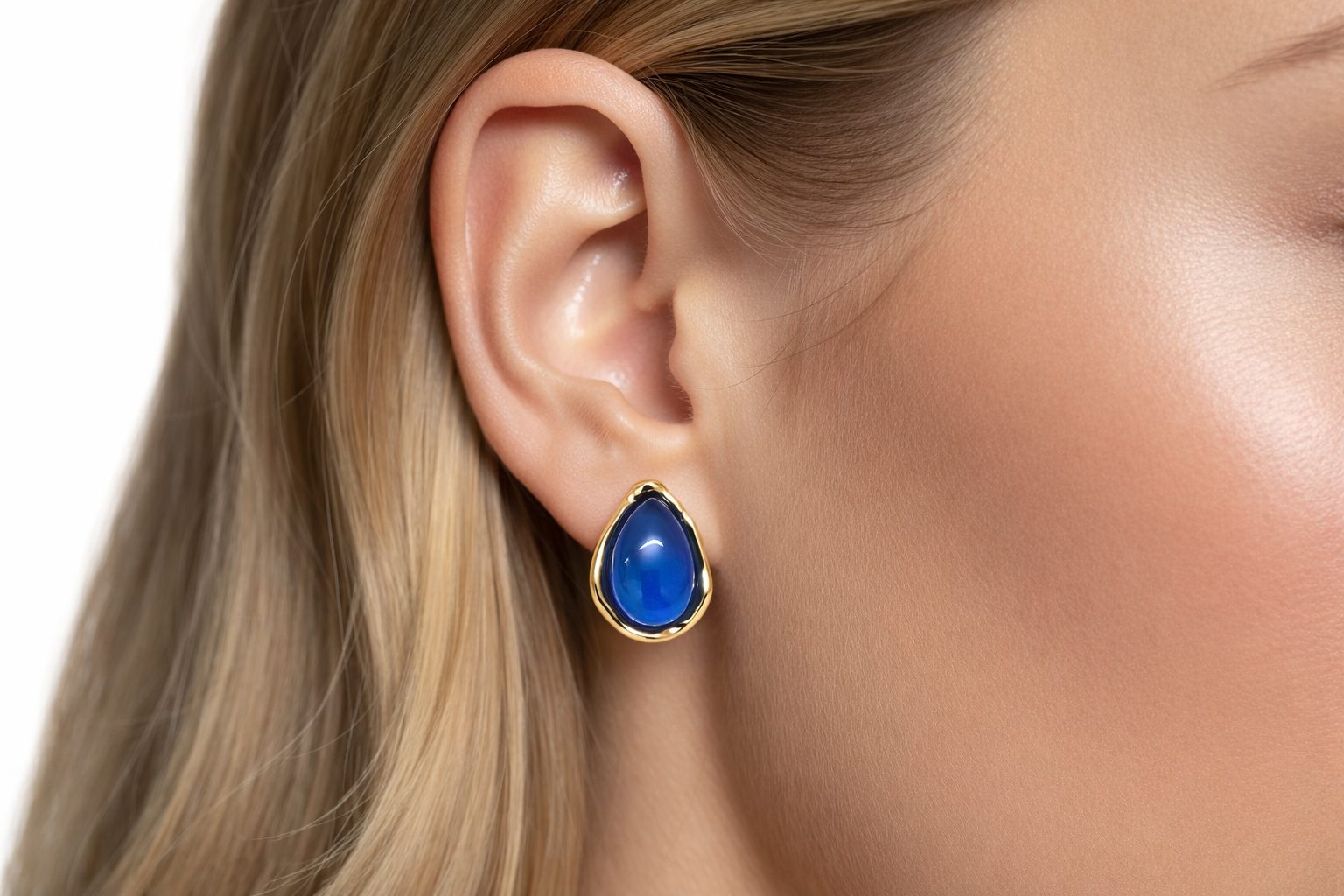Brinco gota azul com aro dourado na orelha de mulher loira