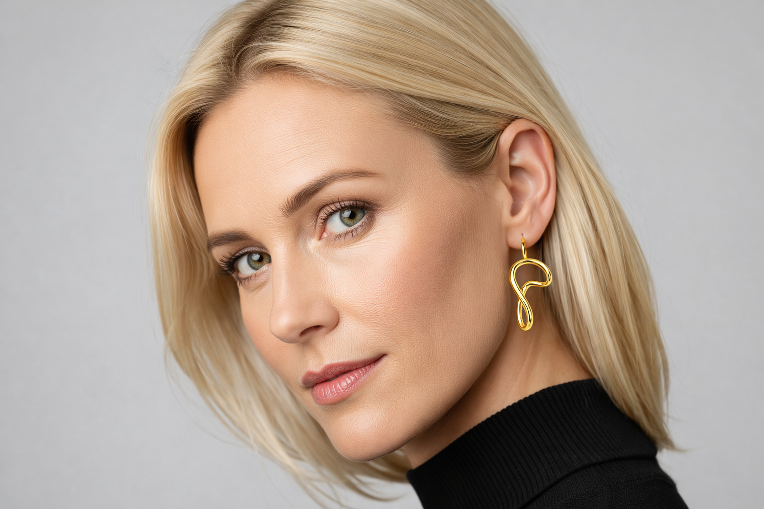 Brincos dourados abstratos usados por mulher loira