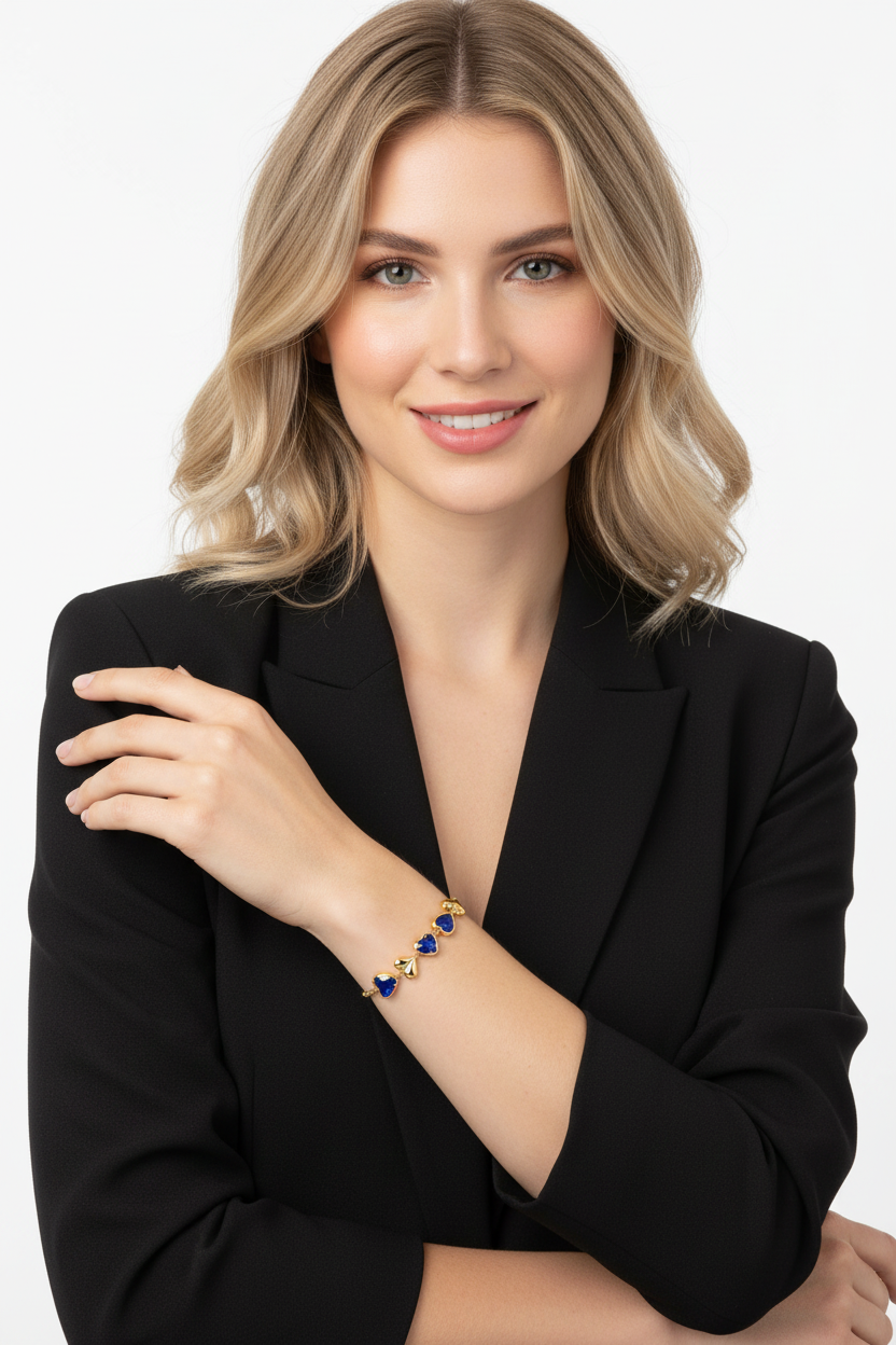 Mulher com pulseira de metal dourado e pedras azuis em formato de coração no pulso