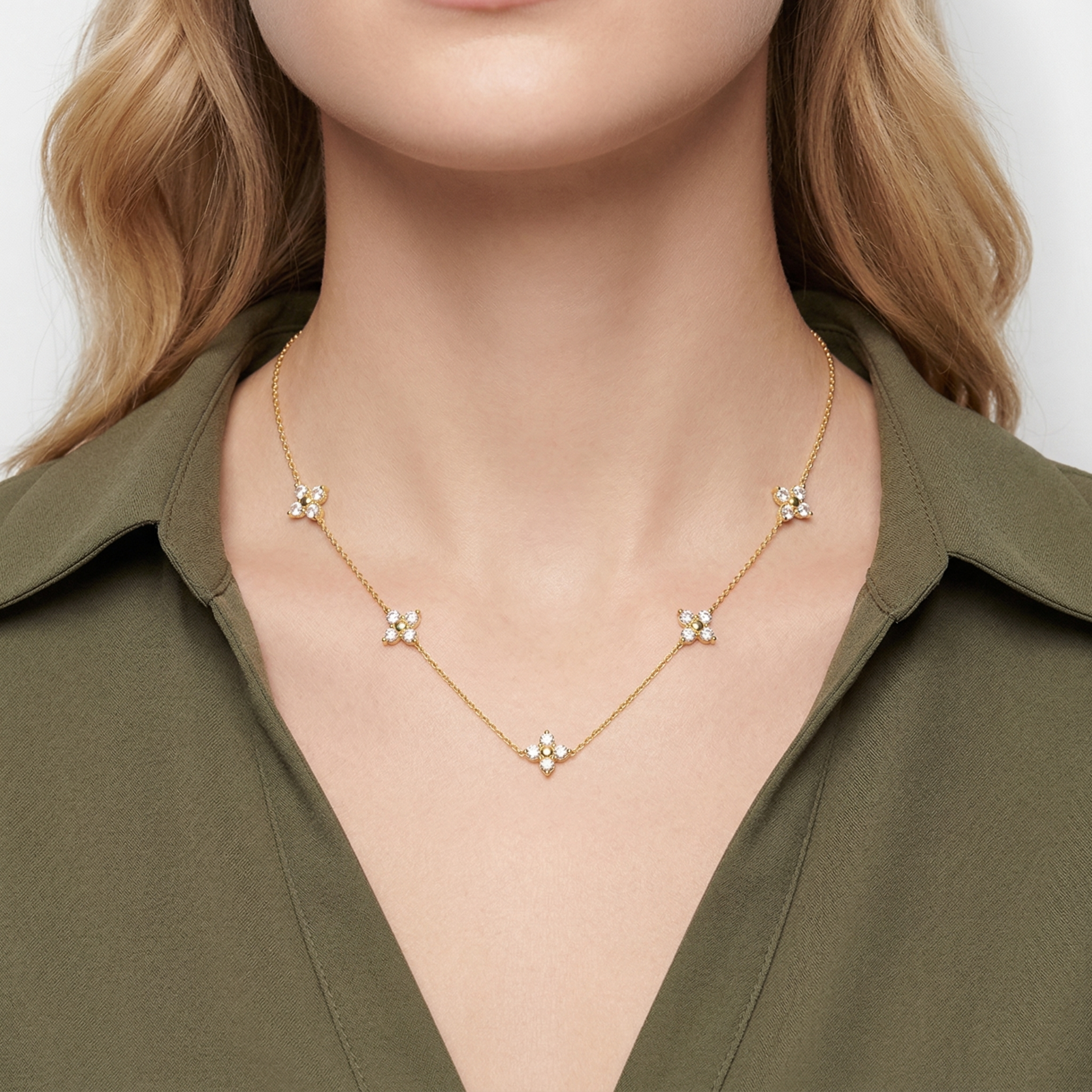Colar dourado com cinco flores de pedras brilhantes usado ao pescoço