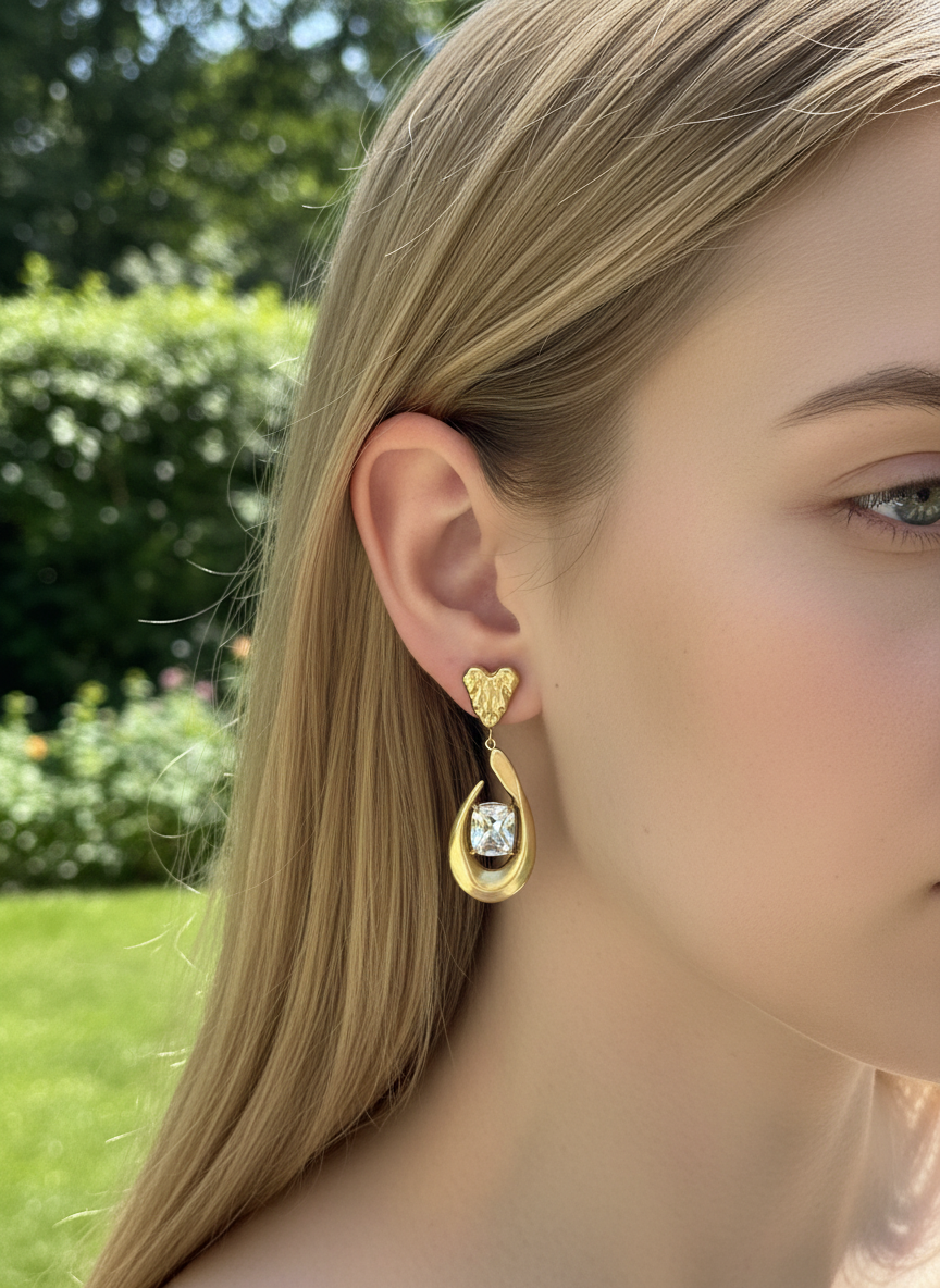 Brinco dourado pendente com pedra quadrada transparente em ouvido feminino