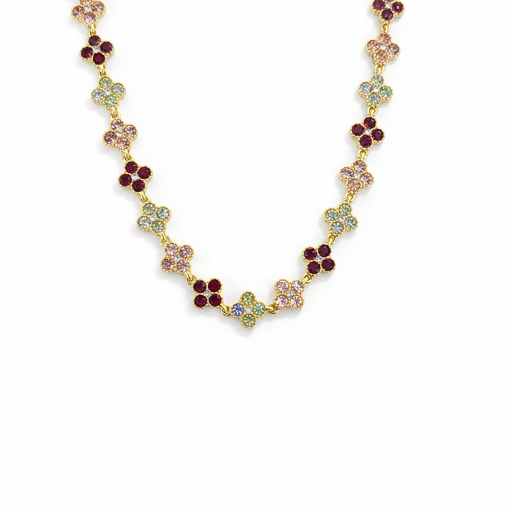 Colar dourado com flores coloridas em fundo branco.