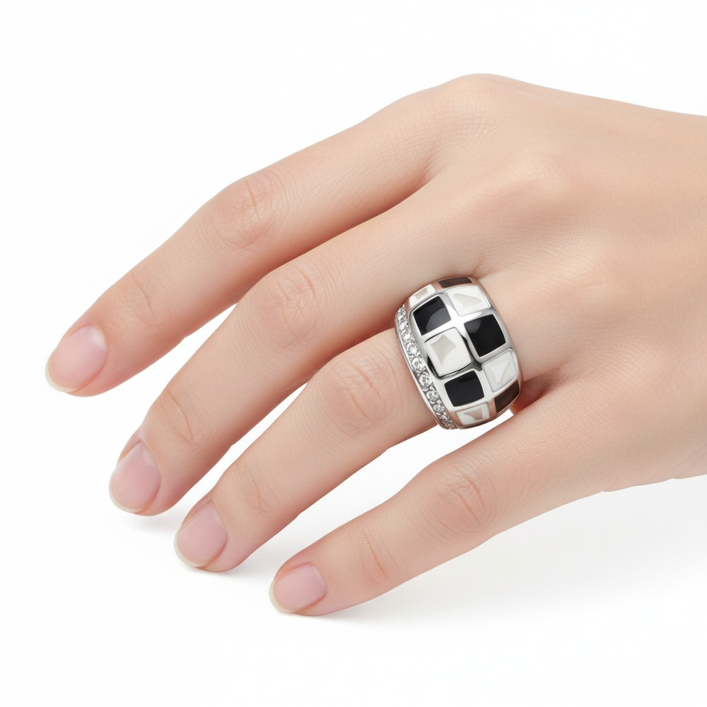 Anel prateado com quadrados brancos e pretos e pedras brilhantes na mão