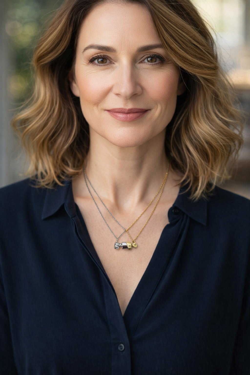 Mulher com colares de doces em prata e dourado e camisa azul escura