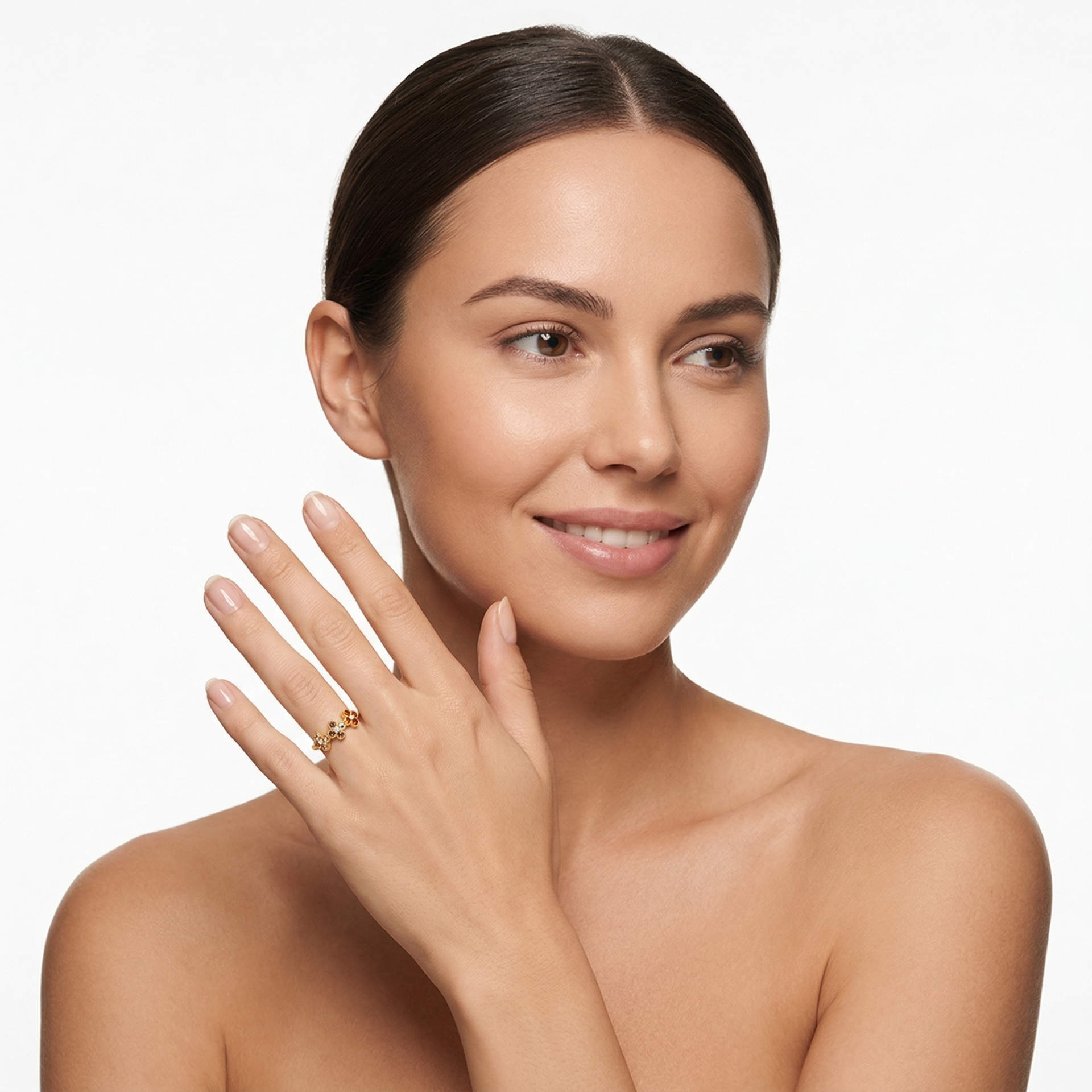 Mulher a usar anel dourado com pedras coloridas no dedo anelar, sobre fundo branco.