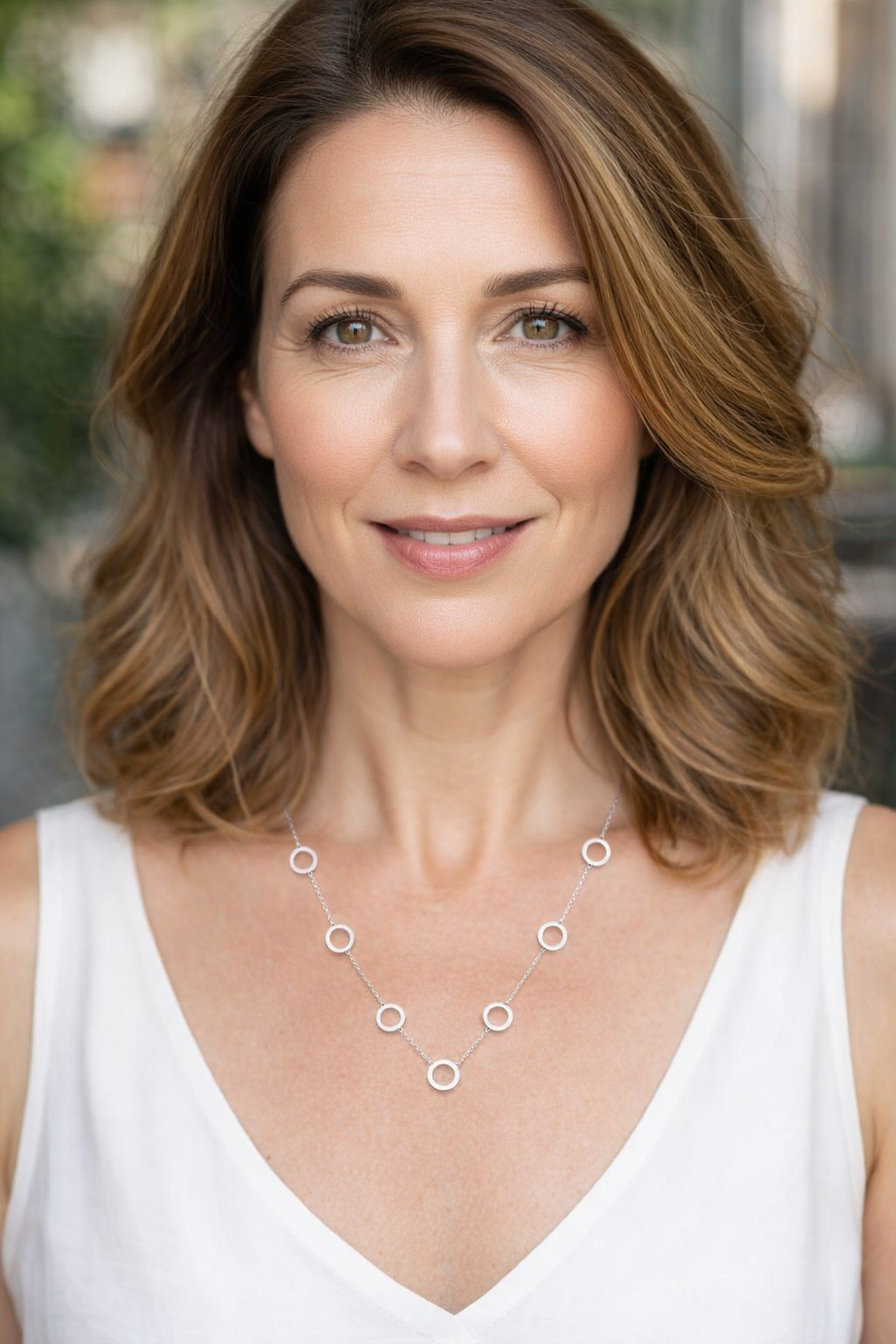 Colar prata com círculos em mulher com camisa branca