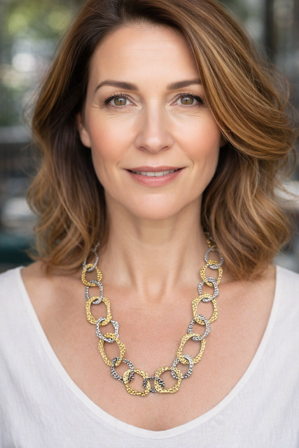 Mulher a usar colar de elos dourados e prateados texturizados