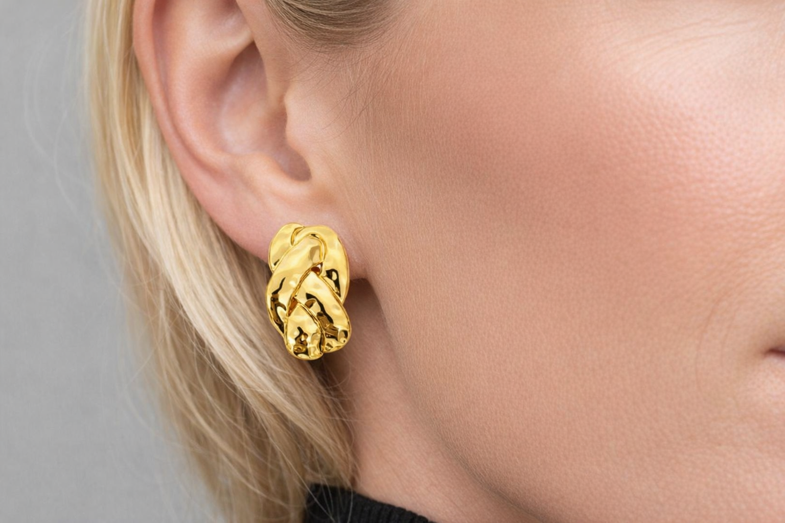 Brinco dourado torcido na orelha de uma pessoa