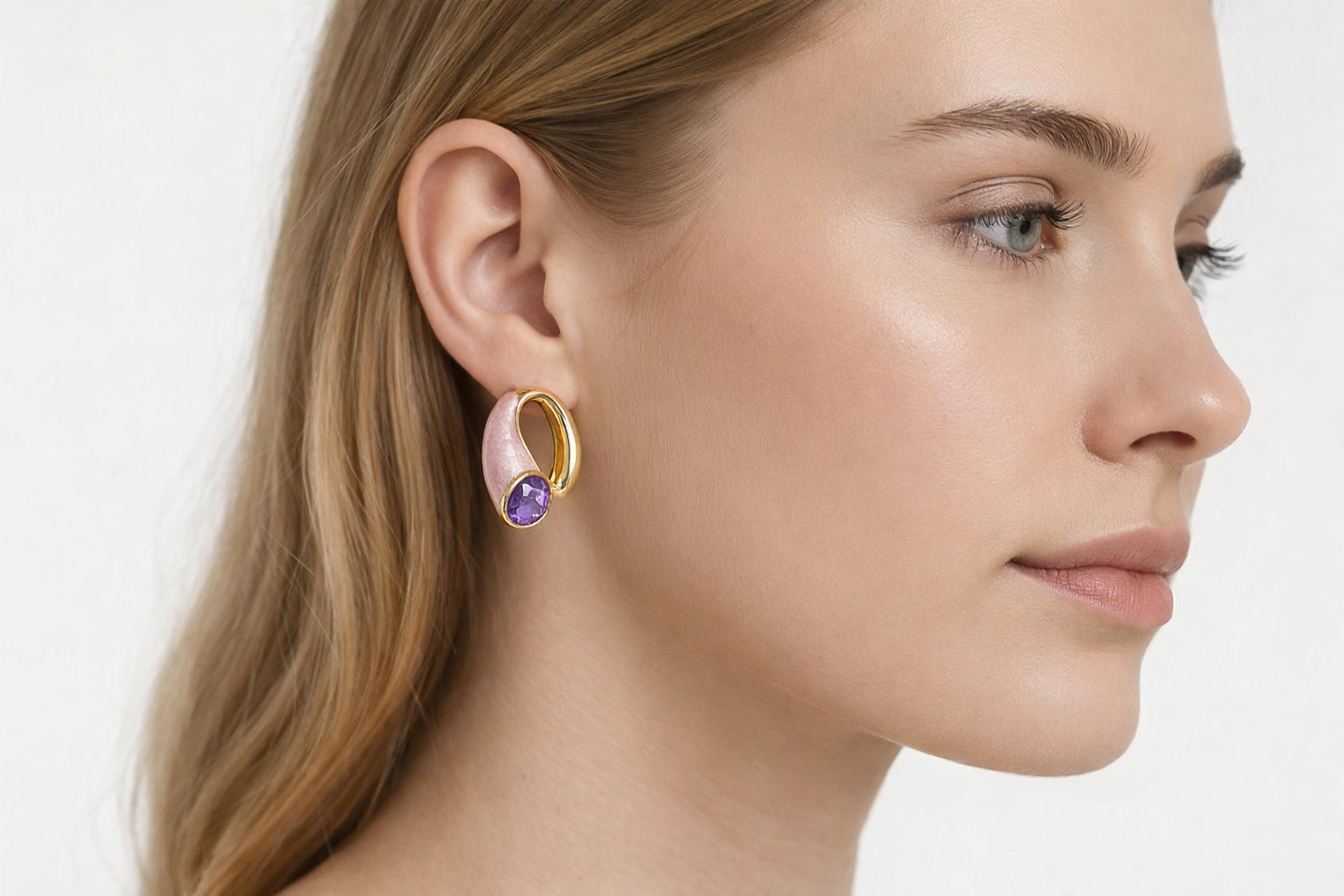 Brinco dourado com detalhe rosa perlado e pedra roxa usado na orelha direita.