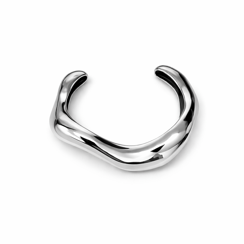 Pulseira de metal prateado curvo e polido sobre fundo branco