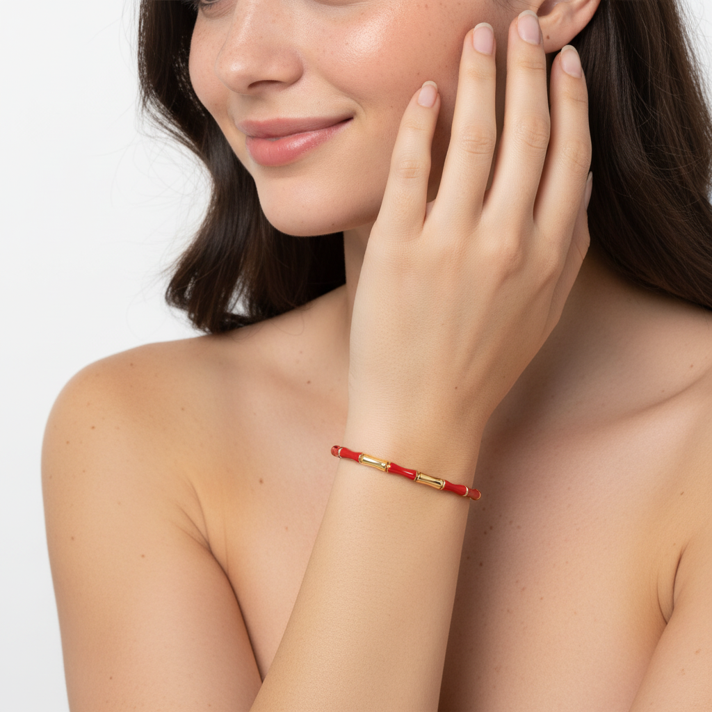 Pulsera vermelha e dourada no pulso de uma mulher