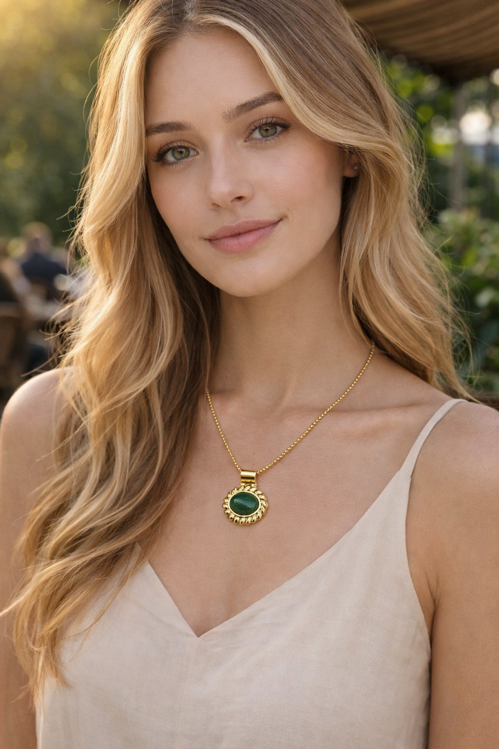 Colar feminino com pedra verde e dourado usado por mulher com vestido bege
