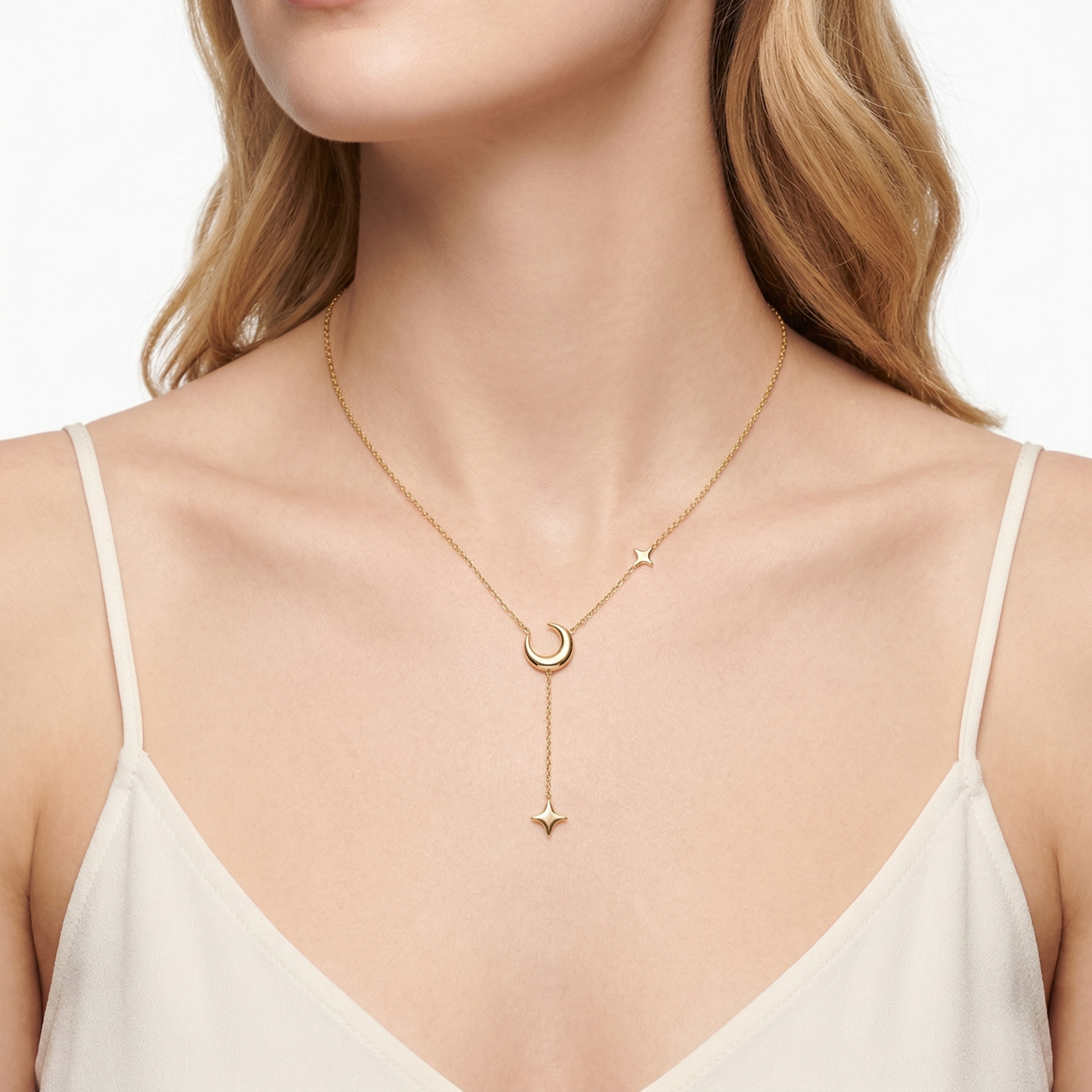 Colar dourado com lua crescente e estrelas em pescoço feminino.
