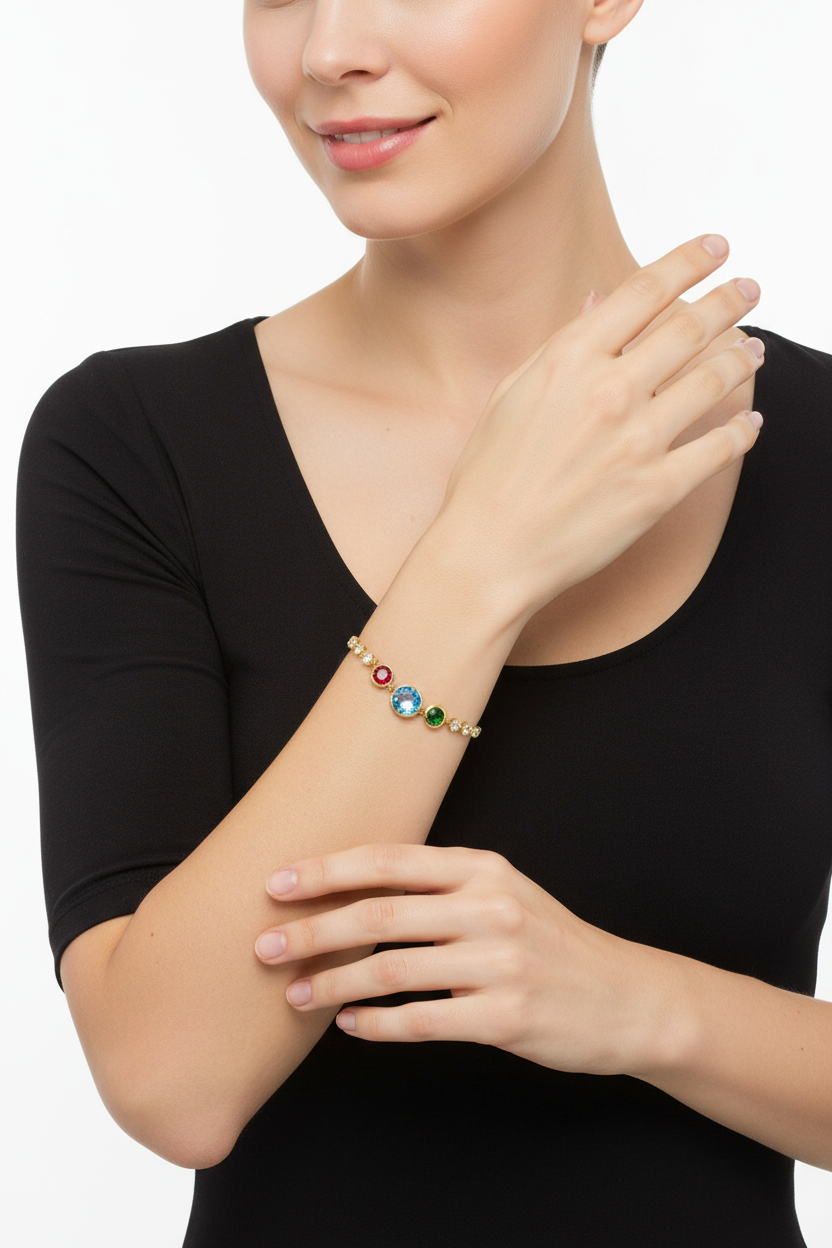 Pulseira dourada com pedras coloridas no braço de mulher com blusa preta