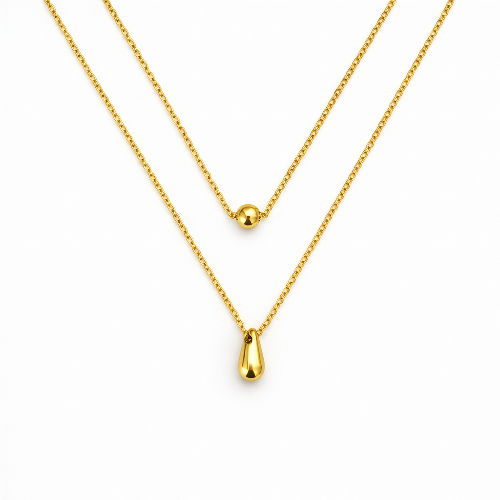 Duas colares douradas com pendentes em esfera e gota sobre fundo branco