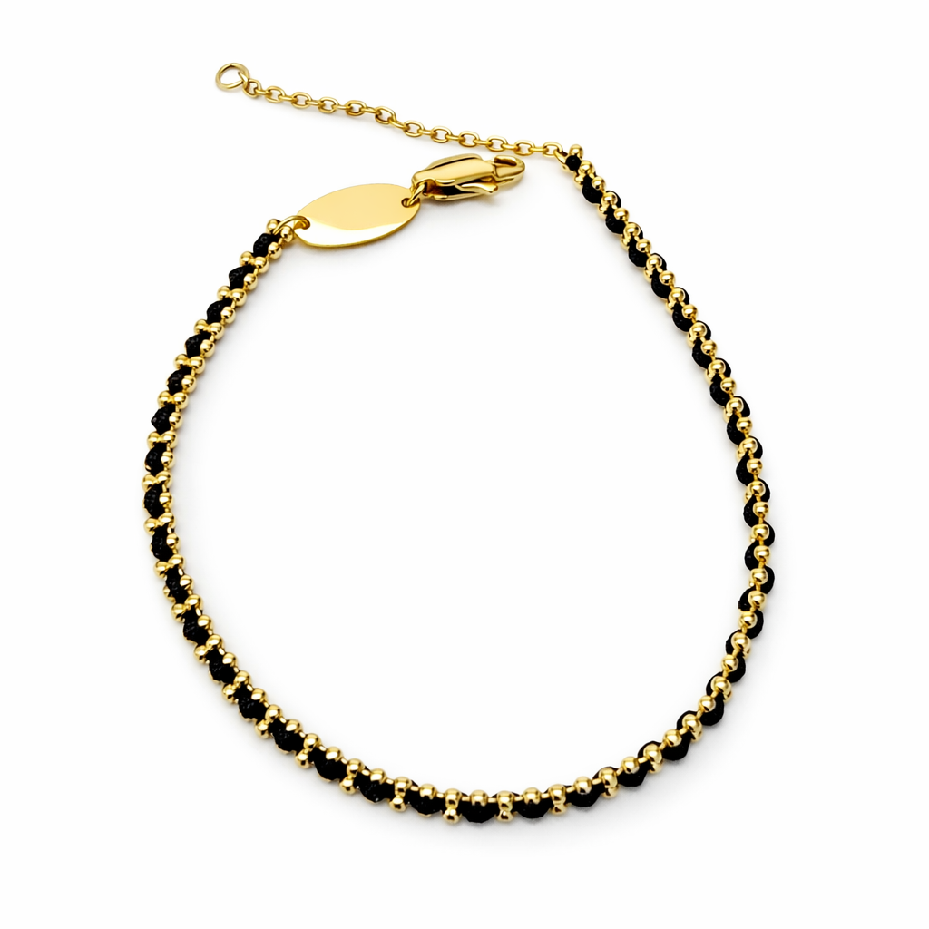 Pulseira fina dourada e preta com placa oval lisa e fecho de lagosta.