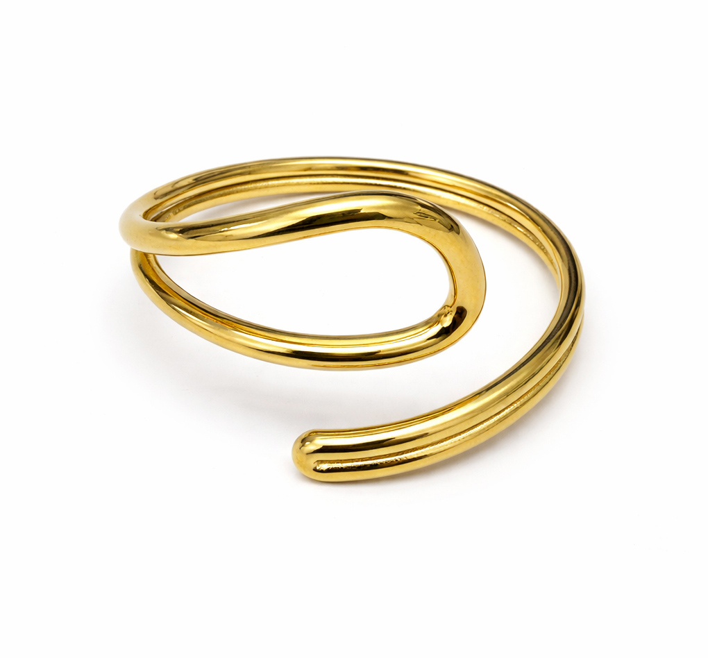Pulseira dourada aberta de metal com design duplo sobre fundo branco