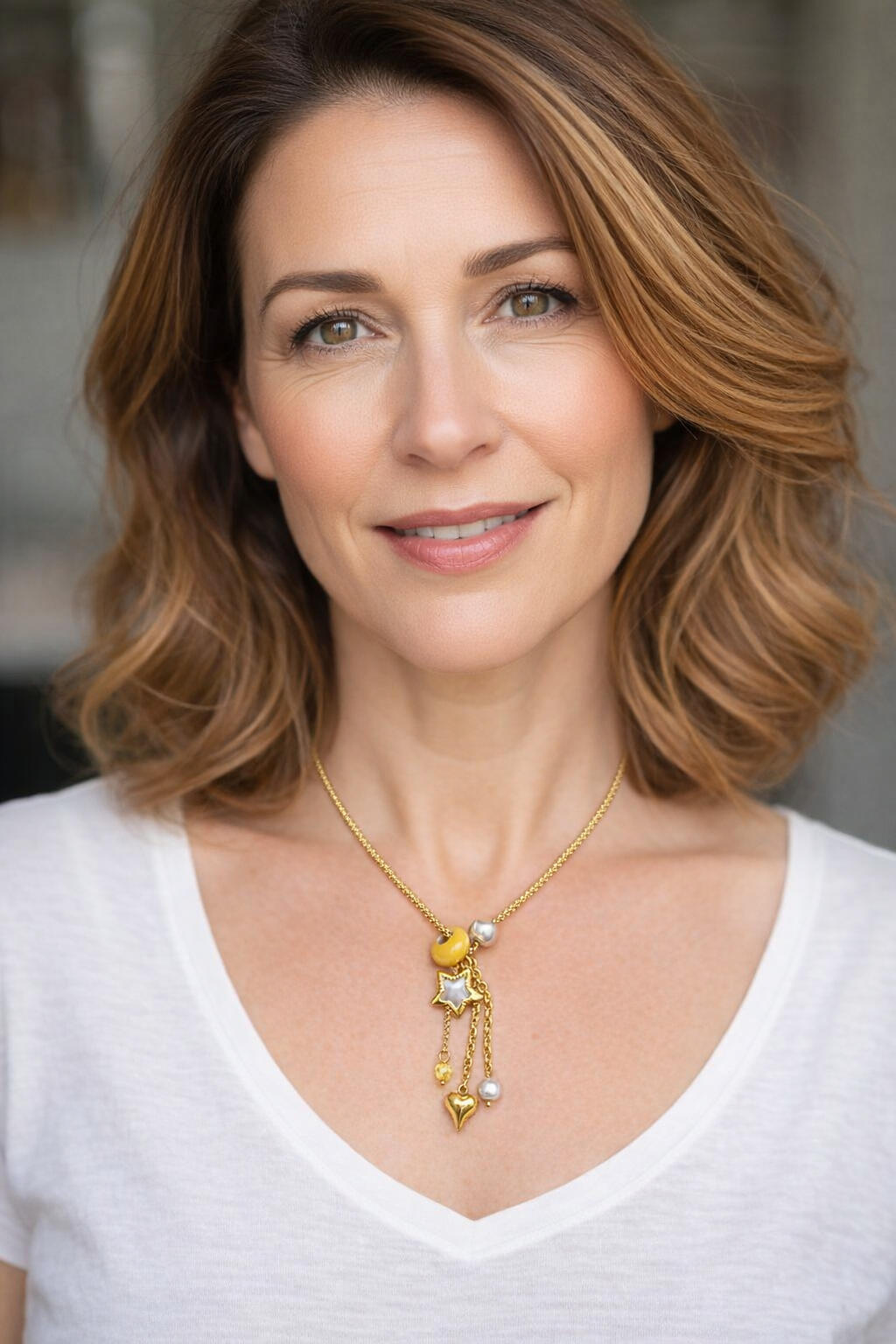 Colar dourado com pingentes em forma de estrela e coração.