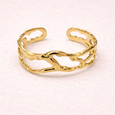 Pulseira dourada aberta com design irregular e recortes artísticos