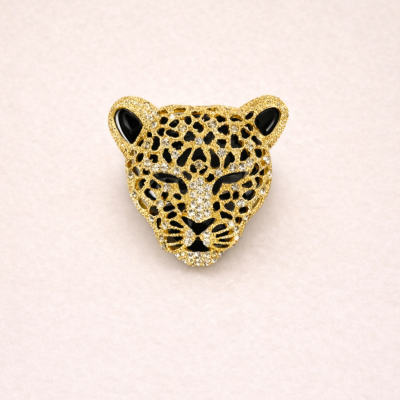 Broche em forma de cabeça de leopardo dourado com pedras brilhantes e detalhes negros