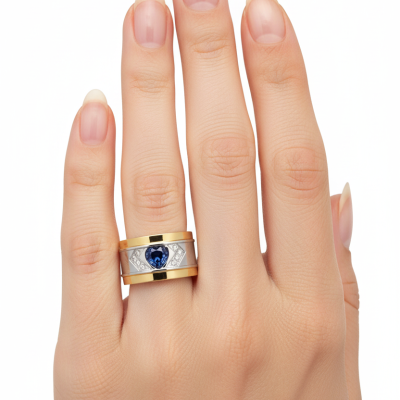 Anel largo bicolor com pedra azul em forma de coração no dedo médio.