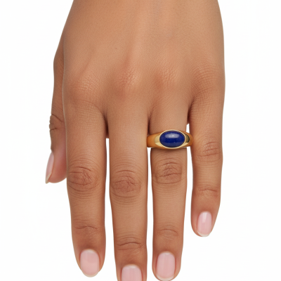 Mão feminina com anel dourado e pedra azul