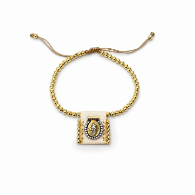 Pulseira com contas douradas e pingente creme com detalhes dourados e pérolas