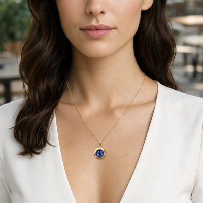 Mulher a usar colar dourado com pendente azul redondo.