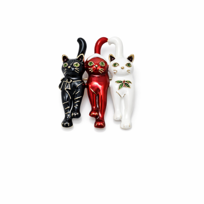Figuras de gatos em cerâmica nas cores preto, vermelho e branco com detalhes dourados.