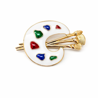 Broche paleta de pintor branca com pincéis dourados e manchas coloridas