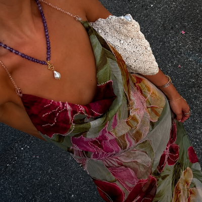 Vestido longo floral em tons verde, vermelho e rosa com bolsa branca texturizada