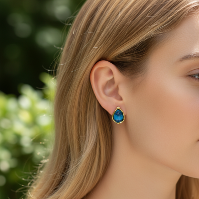 Brinco azul e dourado em orelha de mulher com cabelo loiro