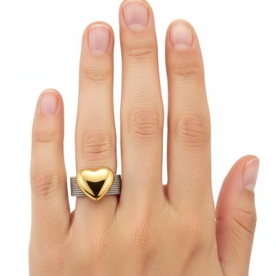 Anel de malha prateada com coração dourado polido em dedo anelar de mão feminina