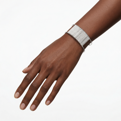 Pulseira prateada sobre pulso de mão com pele escura num fundo branco