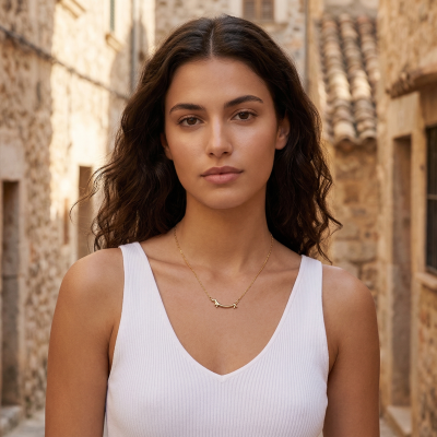 Colar dourado com pingente de cão em modelo com top branco