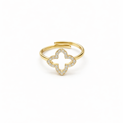 Anel dourado com trevo cravejado em pedras pequenas sobre fundo branco