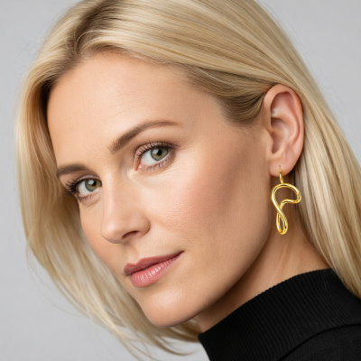 Brincos dourados abstratos usados por mulher loira